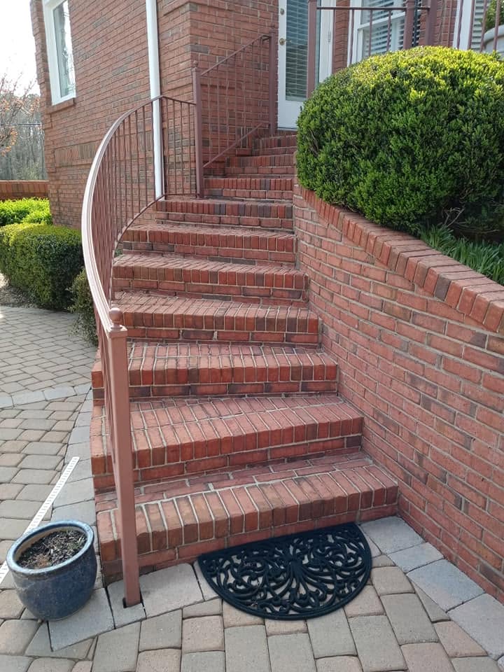 Same curved red brick staircase after cleaning — bright and restored