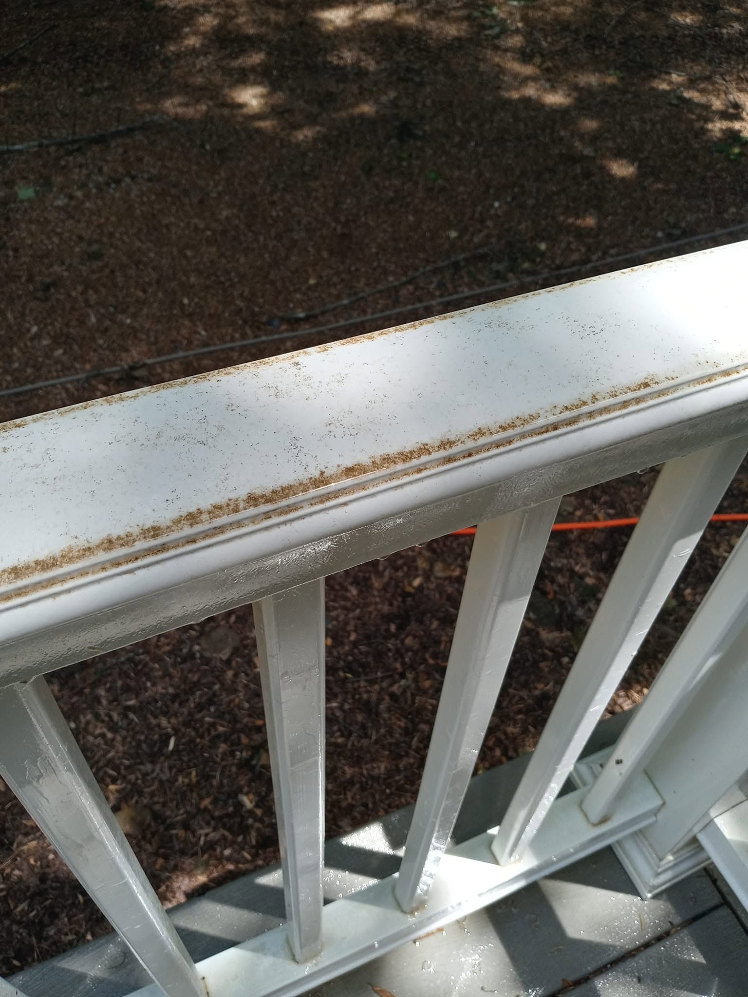 White vinyl handrail with dirt and mildew before cleaning