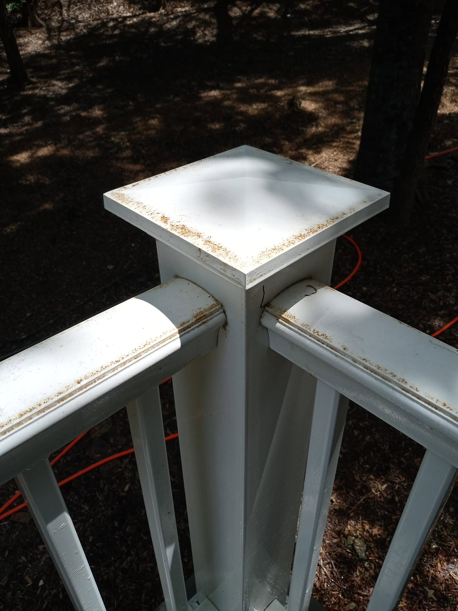 White vinyl deck post with mildew streaks before soft washing