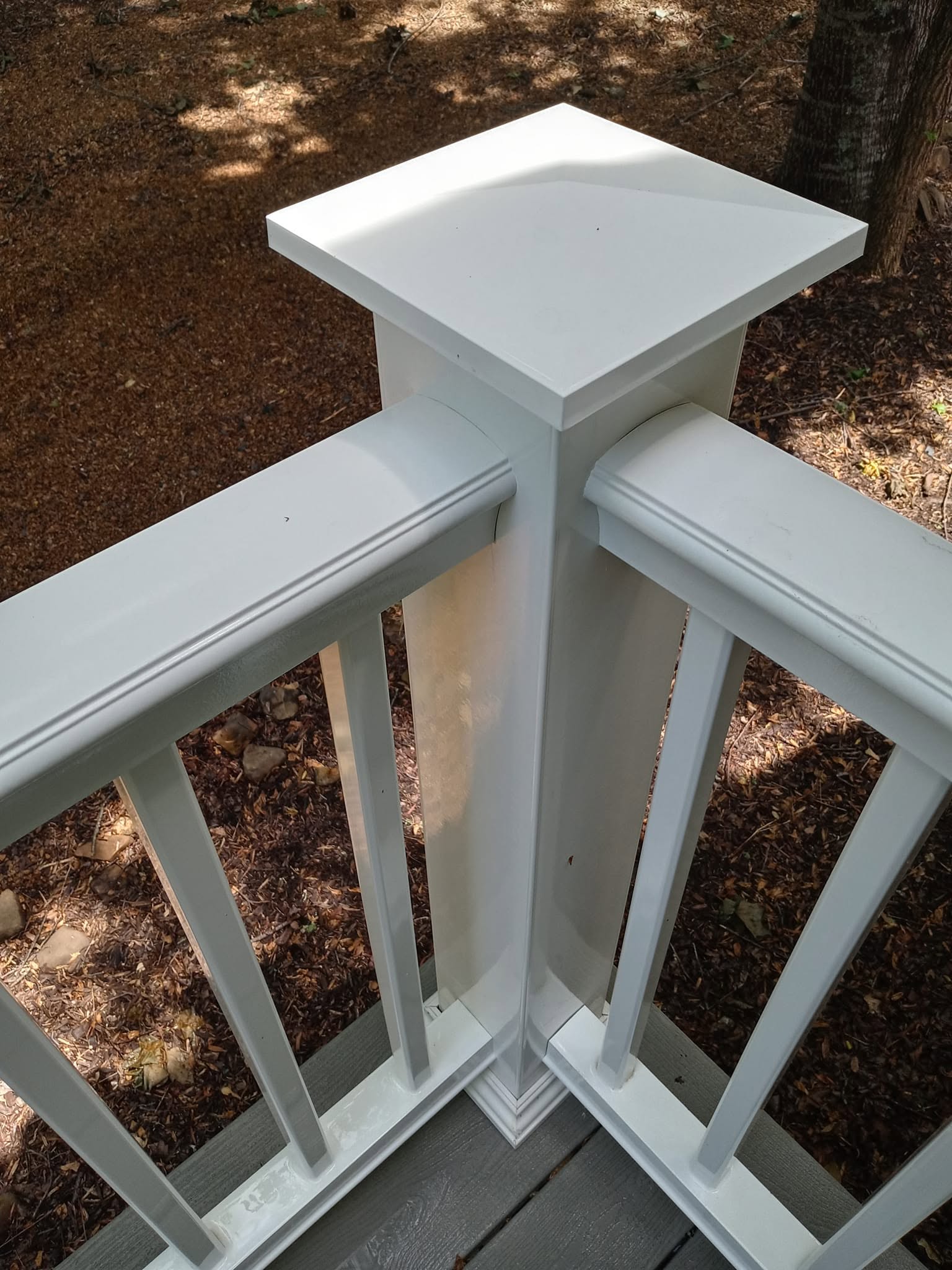 Same white vinyl post after soft washing — clean white finish