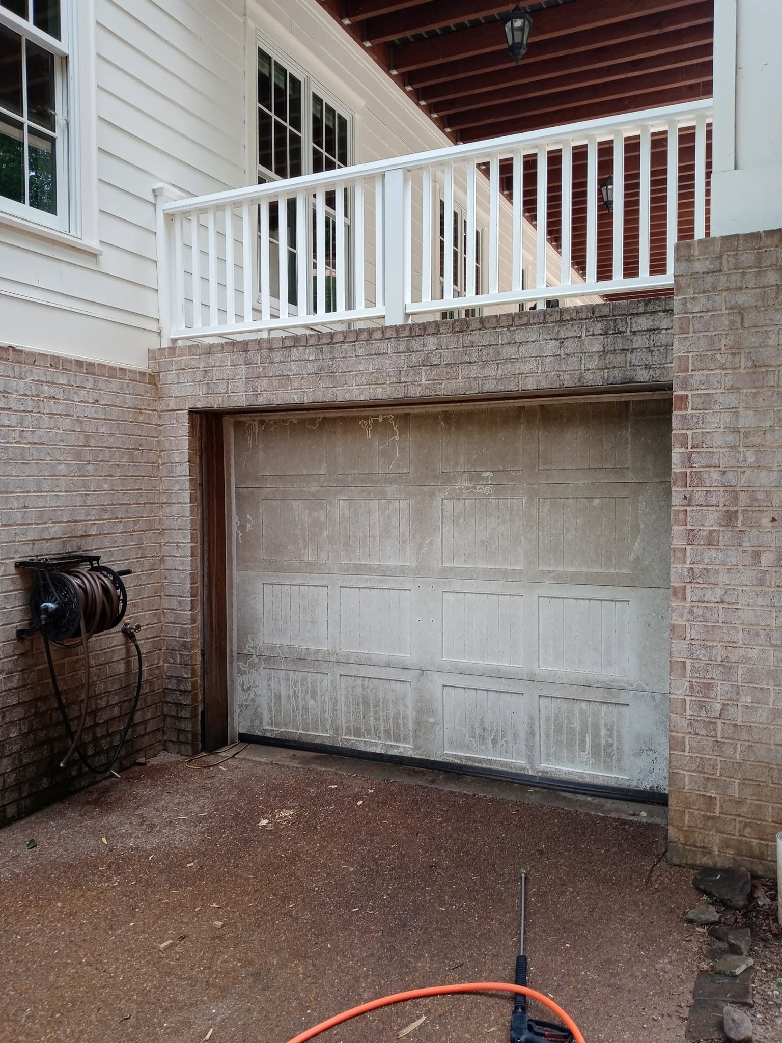 Single-car garage door surround with dirt and mildew before house wash