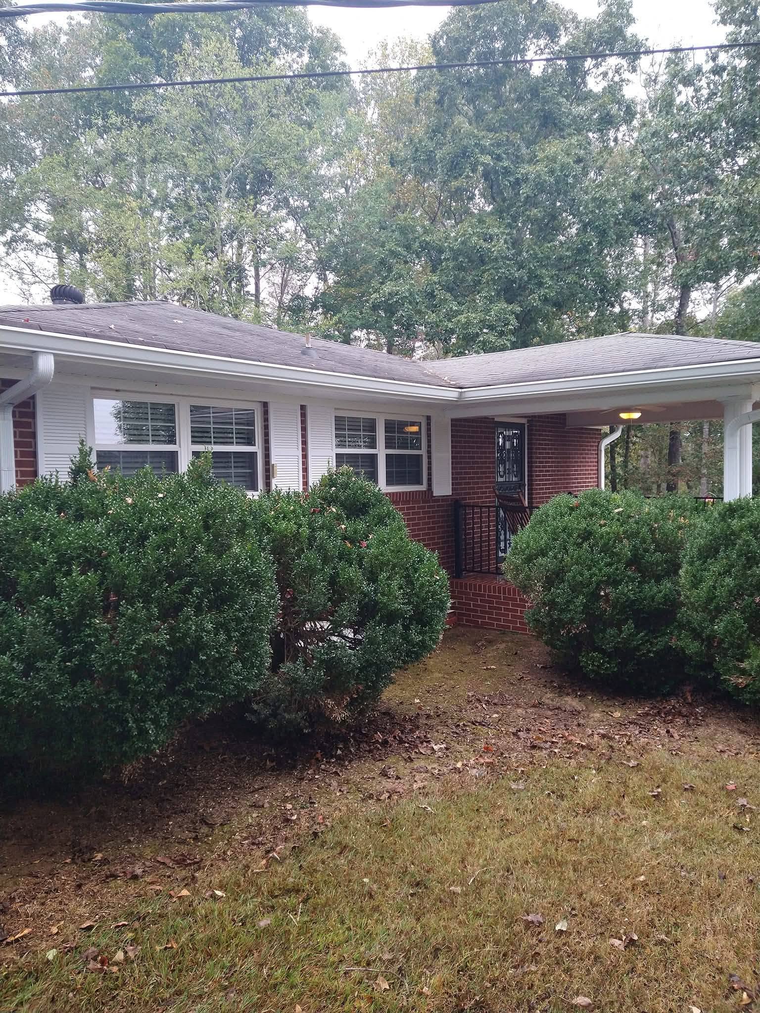 Soft-wash roof and gutter cleaning in progress